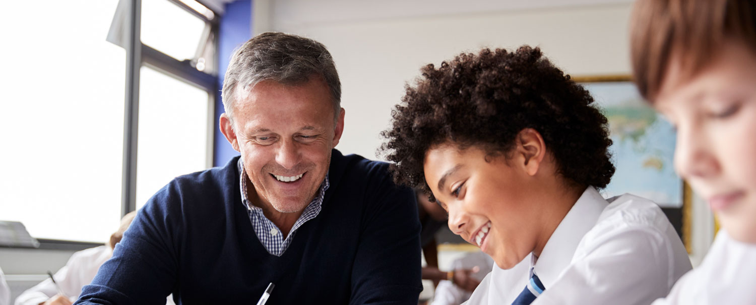 teacher and student happily working together in a classroom