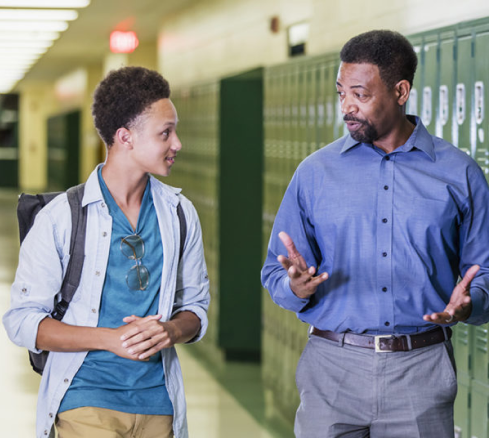 administrator talking to student in the hallway